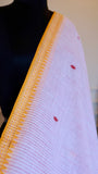 Close-up of mustard temple border on a white Dhonekhali handloom cotton saree.