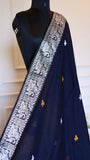 Close-up view of the midnight black Baluchari cotton saree on a mannequin, showcasing the intricate silver border woven with traditional mythological motifs and gold butis.