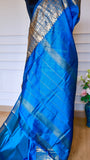Detail view of the lightweight blue semi-silk saree pallu showing fine woven zari lines and metallic sheen.
