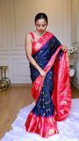 Full body shot of model wearing midnight blue semi Gadwal saree displaying pleats and contrasting pink zari pallu