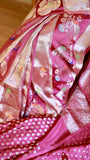 High-resolution close-up detail of the woven silver zari floral meenakari work and Kalash motifs on the magenta Munga Banarasi saree drape.