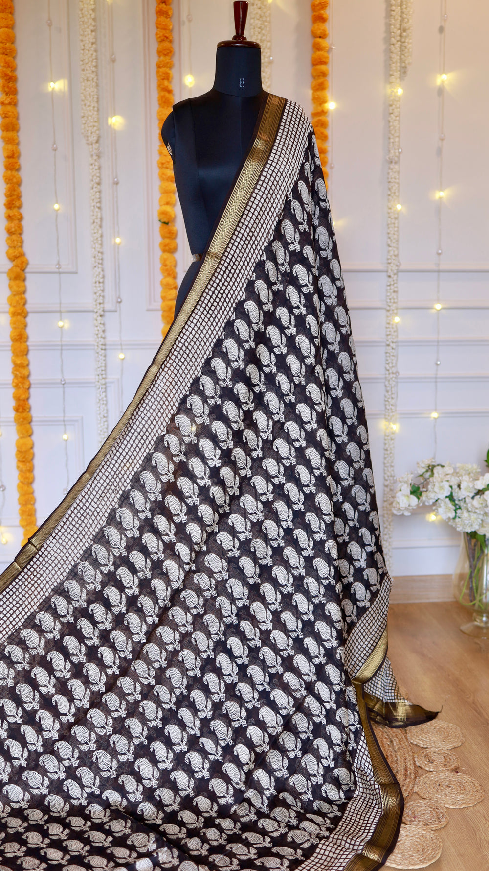Full drape view on mannequin showcasing black paisley motifs and golden woven zari border of Black Maheshwari Silk Saree.