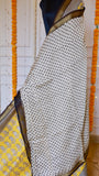Detail view of the off-white polka dot body section and zari border on the Yellow Maheshwari Silk Saree.