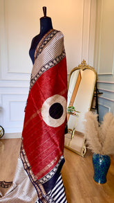 High-contrast shot of the deep red pallu featuring gold Zari stripes and a white circular block-print motif.