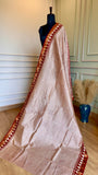 Close-up of Maheshwari Silk Saree fabric showing the intricate gold zari border and geometric triangle patterns.