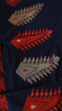 Close-up detail of extra-weft beige and crimson paisley (kalka) motifs woven on black khadi cotton fabric.