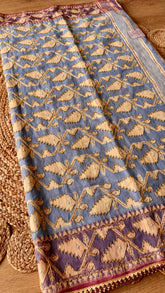 Full view of powder blue Kardana Jamdani saree spread out featuring golden leaf vine weave with hand-beaded detailing.