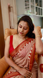 Model wearing a Titafu Maheshwari Silk Saree with red horizontal stripes, a cream base, and traditional triangle borders on a staircase.