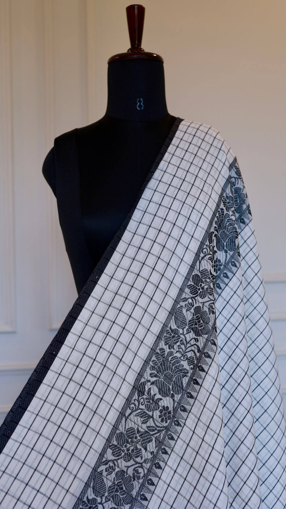Detail view of the monochrome check pattern and woven border of a
Dhonekhali saree.