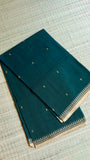 Folded Emerald Green Dhonekhali Saree showcasing the uniform weave and delicate golden thread motifs