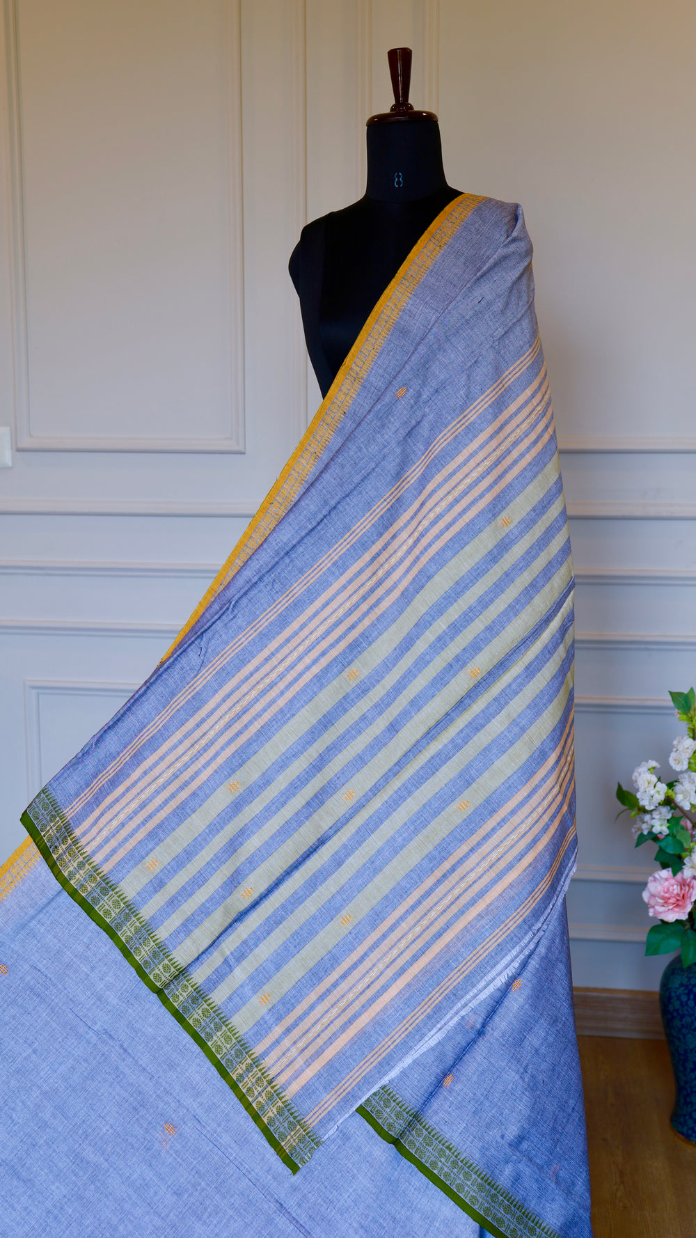 Full view of a Steel Blue Dhonekhali Handloom Cotton Saree with ochre and olive green thread work borders on a mannequin.