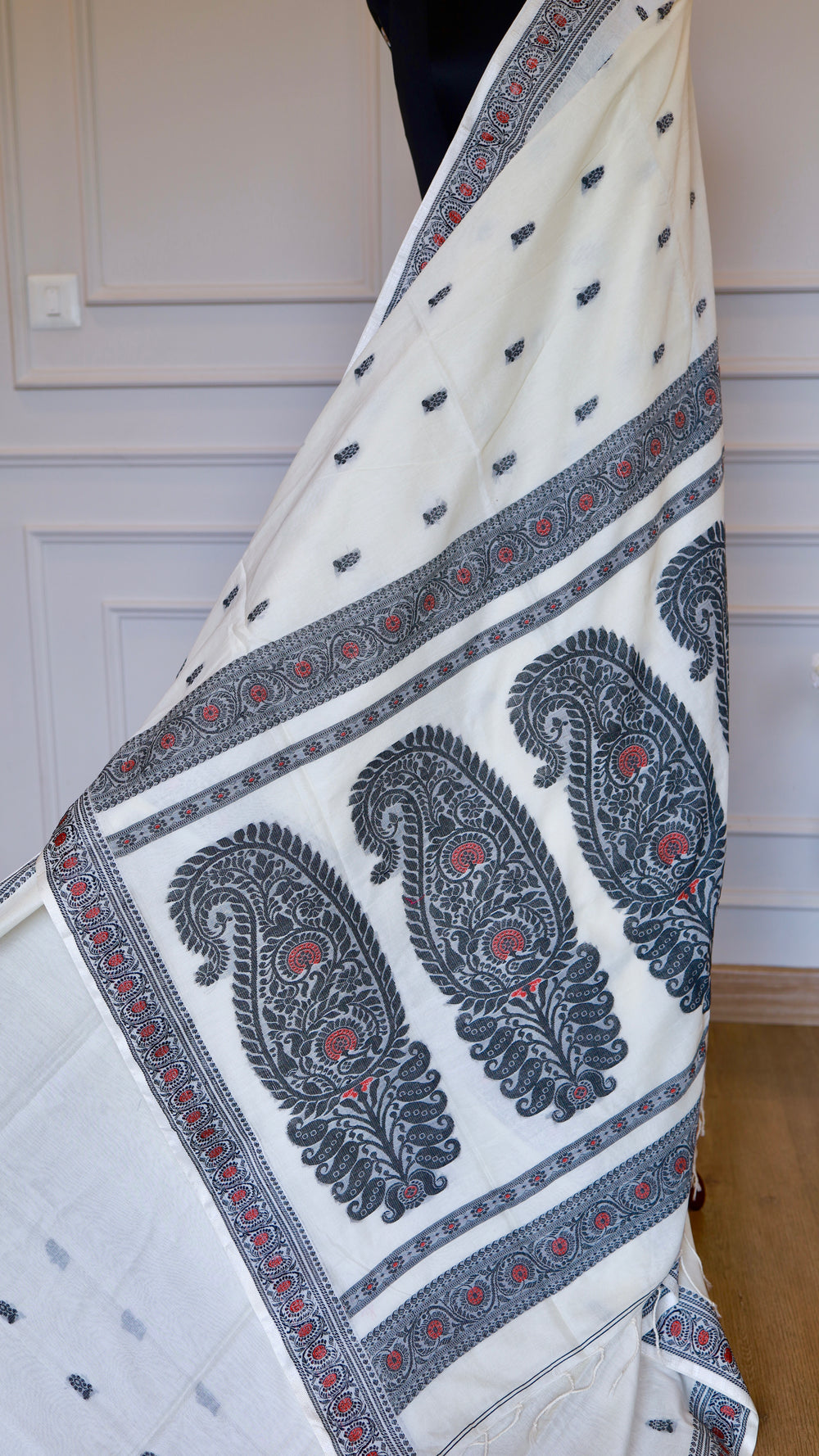 Close-up view of the pallu on an off-white Baluchari Cotton Saree showcasing three large black and crimson paisley motifs.