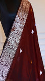 Detailed close-up section of the silver-accented border of the maroon Baluchari Cotton Saree, displaying the precise textile art and human craftsmanship of the narrative weave.