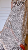 Detailed view of the lower half of the Maheshwari Silk Saree, showcasing a contrasting cream and black circular sunburst handblock print pattern layered against the chevron body.