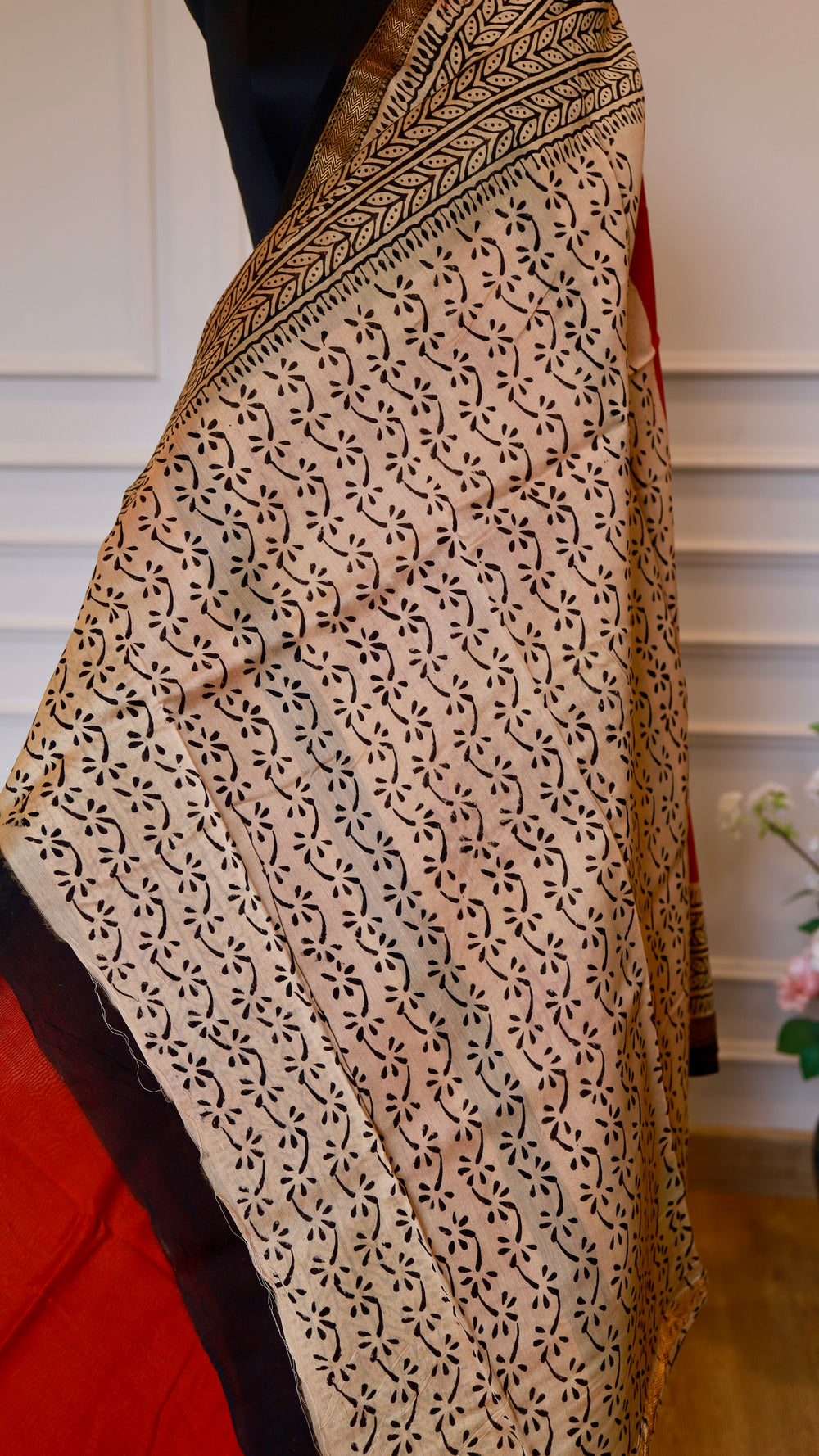 Close-up shot of the cream and black handblock printed section of the Titafu Maheshwari silk saree, showcasing intricate repeated leaf and floral bud motifs stamped with natural black dye.