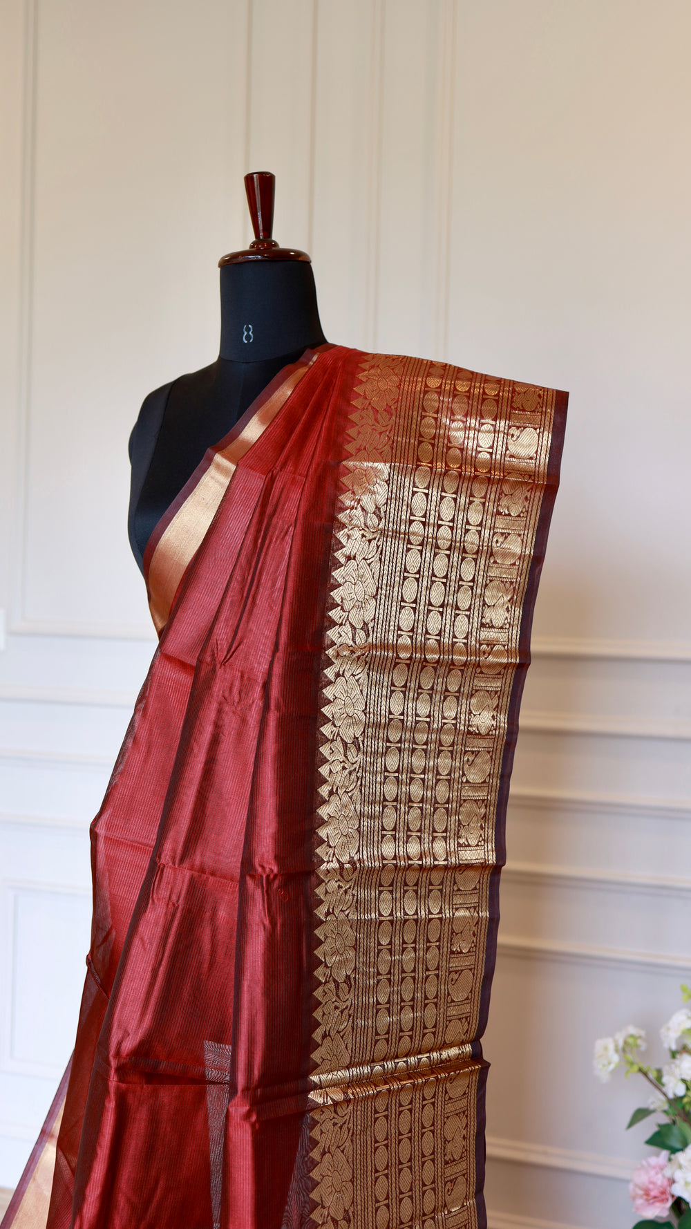 Close up shot of Crimson Red Mangalagiri Semi Silk Saree displaying detailed geometric and floral gold zari nizam border