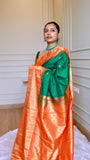 Close-up view of model draped in bottle green semi Gadwal saree with gold choker necklace and traditional nose ring.