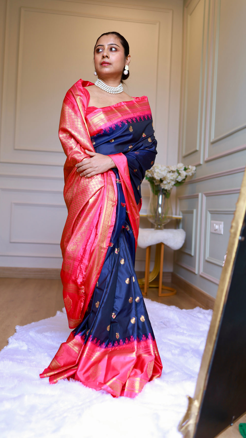 Model showcasing the drape and rich golden zari pallu detail of Titafu navy blue and pink semi Gadwal silk saree