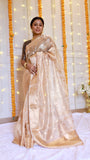 Front full-length view of a model wearing a champagne gold handwoven pure tissue silk banarasi saree styled with traditional gold jewelry.