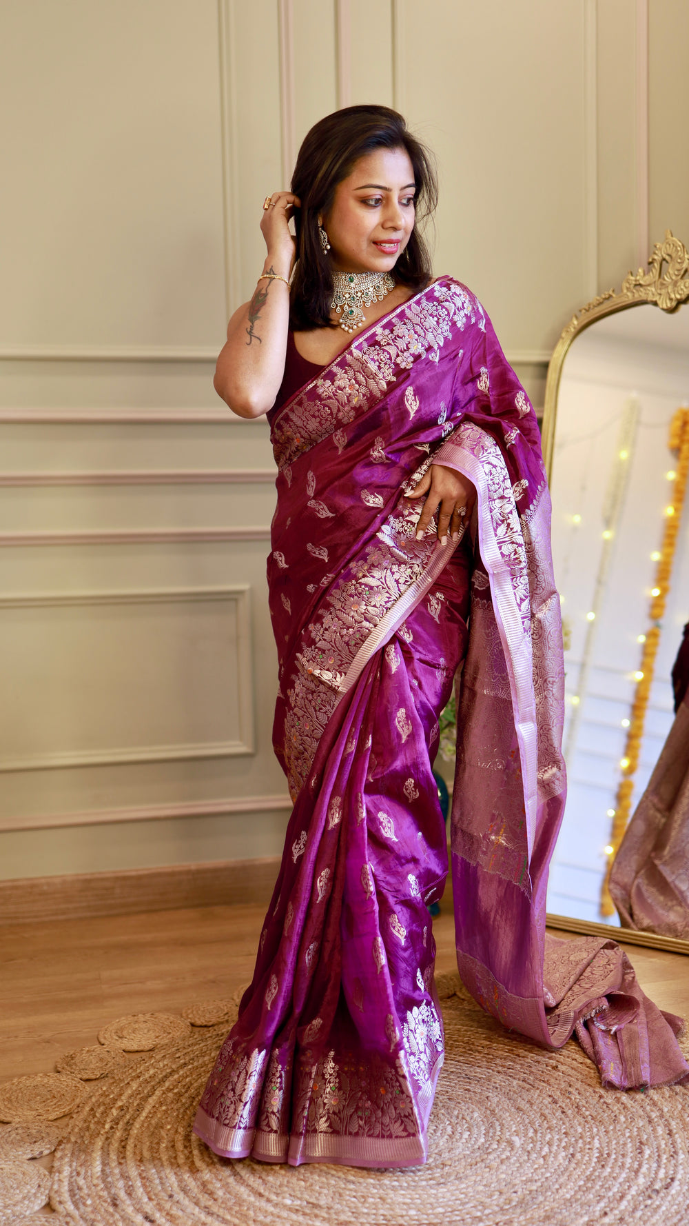 Full-length view of a model standing in a royal purple georgette Banarasi saree showing the elegant drape and pleats.