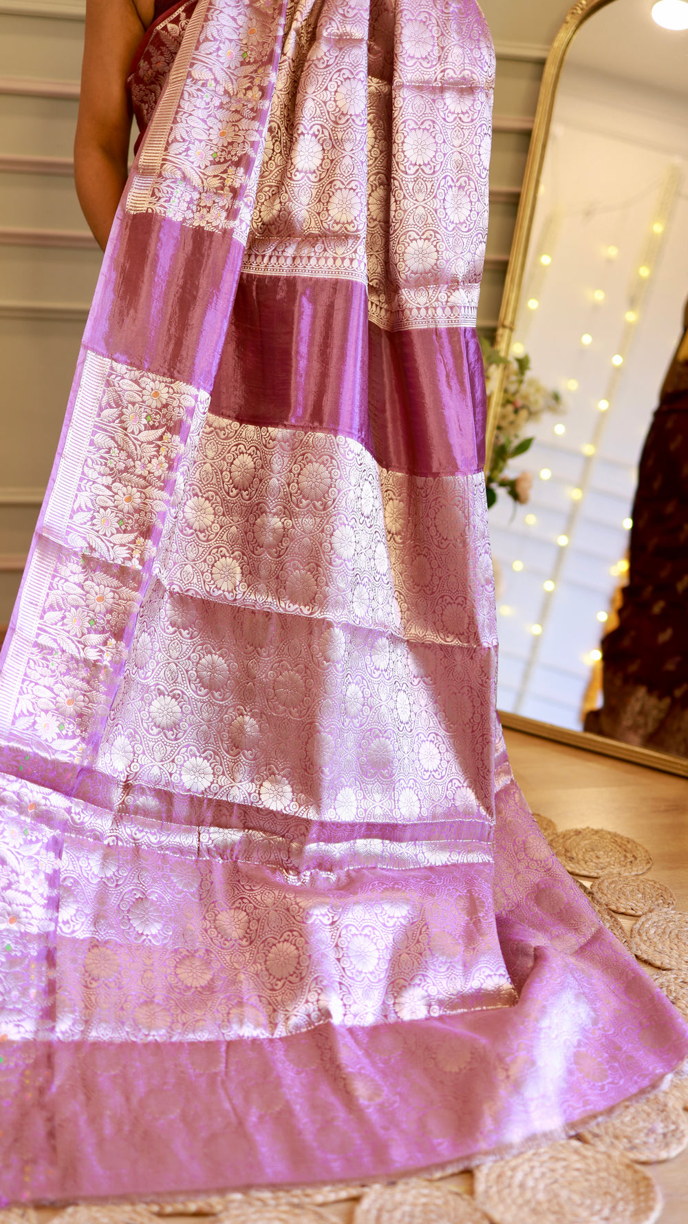 Full view of the ornate silver zari woven pallu section on a light purple and plum Banarasi georgette saree.