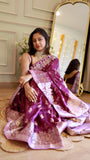 Front-facing shot of a model seated, showcasing the rich silver zari border details of the purple Banarasi saree.