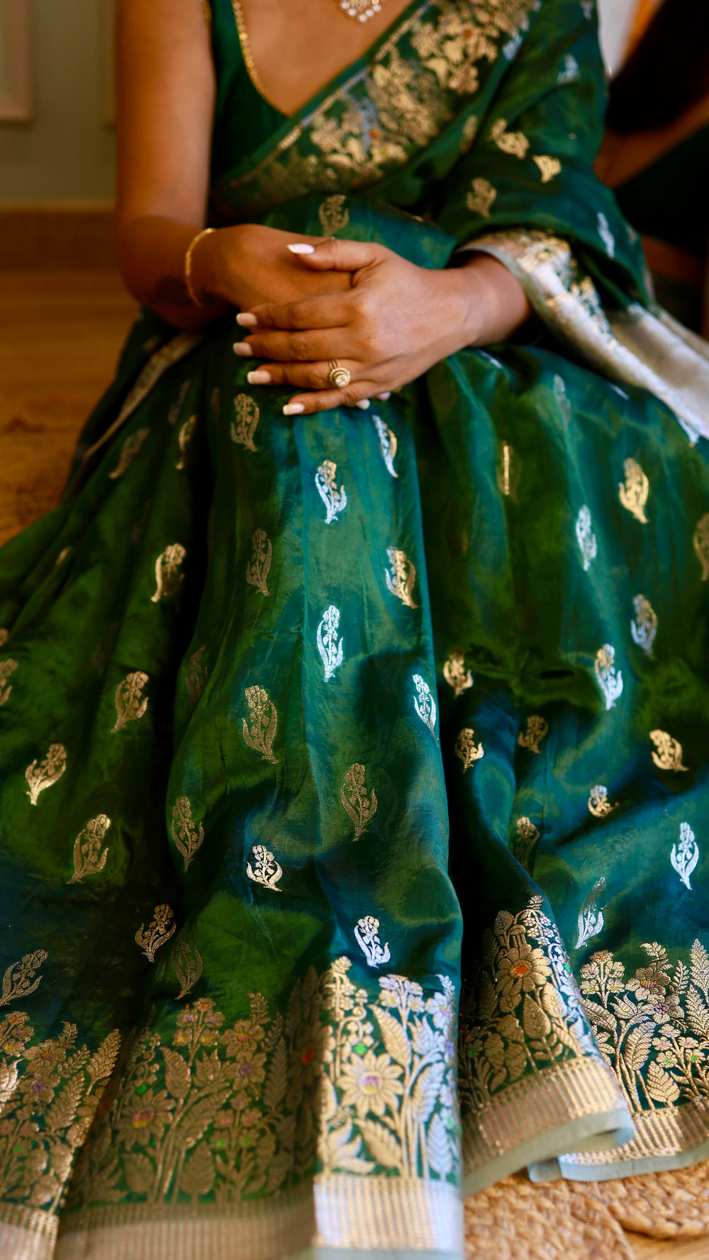 Close-up shot showing the soft texture and silver zari bootis of the green Banarasi georgette drape.