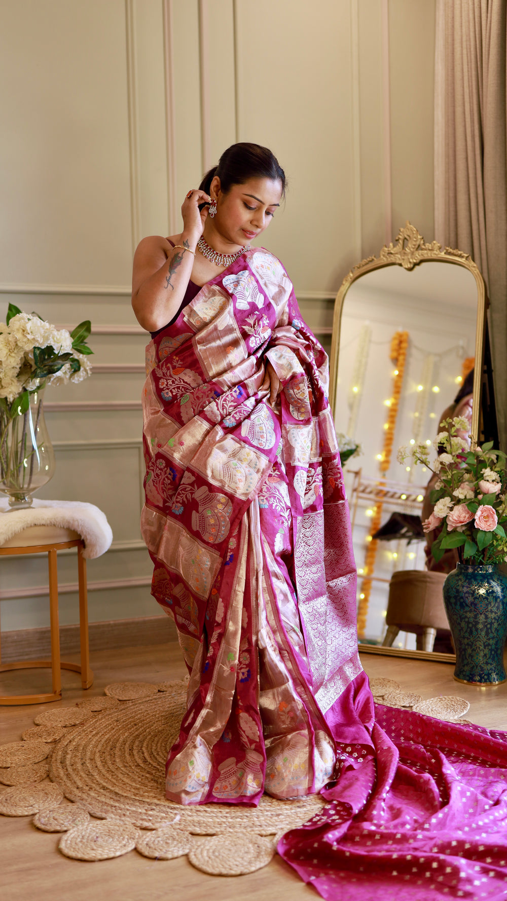 Full-length view of model standing in a magenta Munga Banarasi silk saree showcasing the pleats, drape, and matching woven blouse piece fabric laid on the floor.