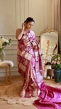 Full-length view of model standing in a magenta Munga Banarasi silk saree showcasing the pleats, drape, and matching woven blouse piece fabric laid on the floor.