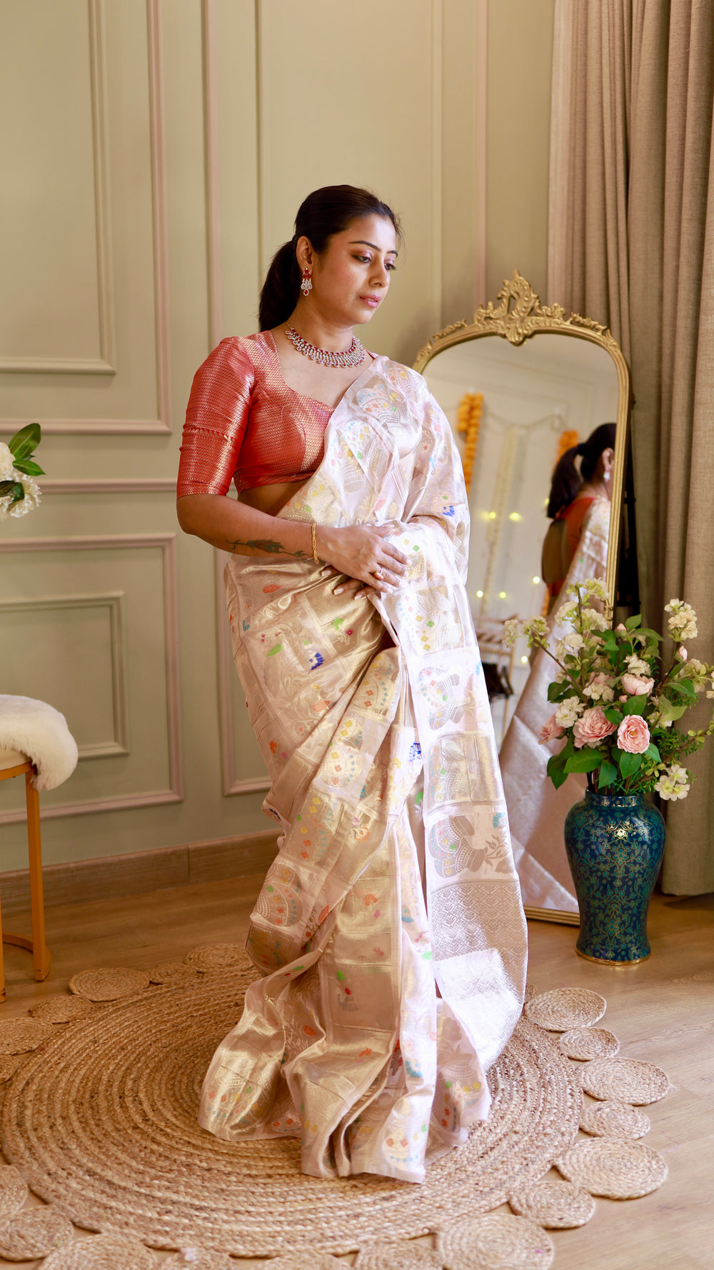 Full-length view of model draping the lightweight ivory Munga Contrast Banarasi Saree next to a gold ornate mirror.