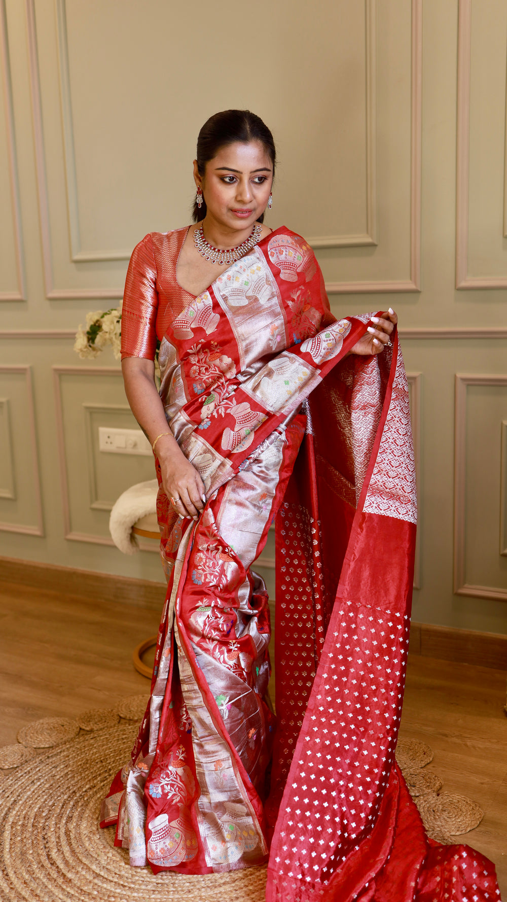 Full-length view of model draping the crimson red Munga contrast Banarasi saree showcasing the silver zari pallu and Kalash motifs.