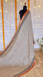 Full mannequin drape of off-white and black block-printed Maheshwari silk saree with rust red zari border