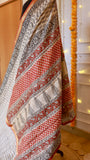 Elaborate rust red and black geometric block printed pallu on off-white handloom Maheshwari silk saree