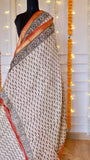 Detailed shot of leaf motif block printing and woven zari border on off-white Maheshwari silk saree
