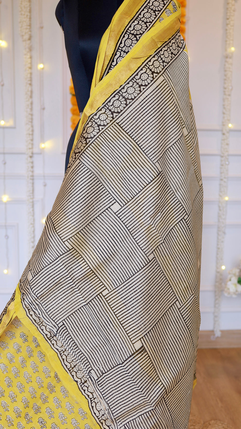 Close-up shot of criss-cross geometric handblock striped pattern on cream and yellow Maheshwari silk saree pallu