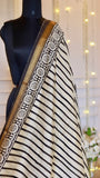 Close-up of Off-White Maheshwari Silk Saree featuring black diagonal stripes and a gold Zari floral border.