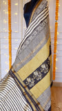Richly patterned pallu of Maheshwari Silk Saree showing floral block prints on mustard and black panels.