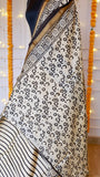 Detailed view of the circular block-print pattern on an off-white handloom silk saree fabric.