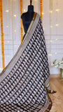 Full drape view on mannequin showcasing black paisley motifs and golden woven zari border of Black Maheshwari Silk Saree.