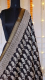 Upper bodice drape showing dense off-white paisley print against charcoal black base and woven gold zari border on Black Maheshwari Silk Saree.
