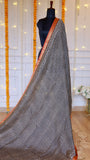Full drape view of black and off-white geometric hand-block printed Maheshwari silk saree on mannequin with rust orange zari border