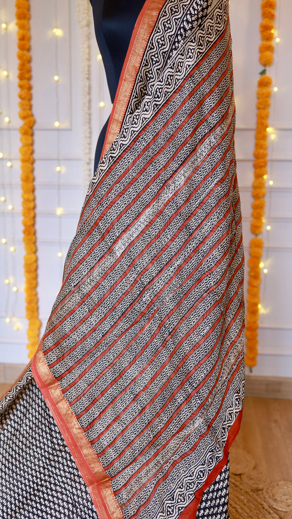 Detailed view of diagonal printed pallu with wavy block motifs and rust orange border on Maheshwari silk saree