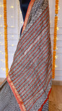 Detailed view of diagonal printed pallu with wavy block motifs and rust orange border on Maheshwari silk saree