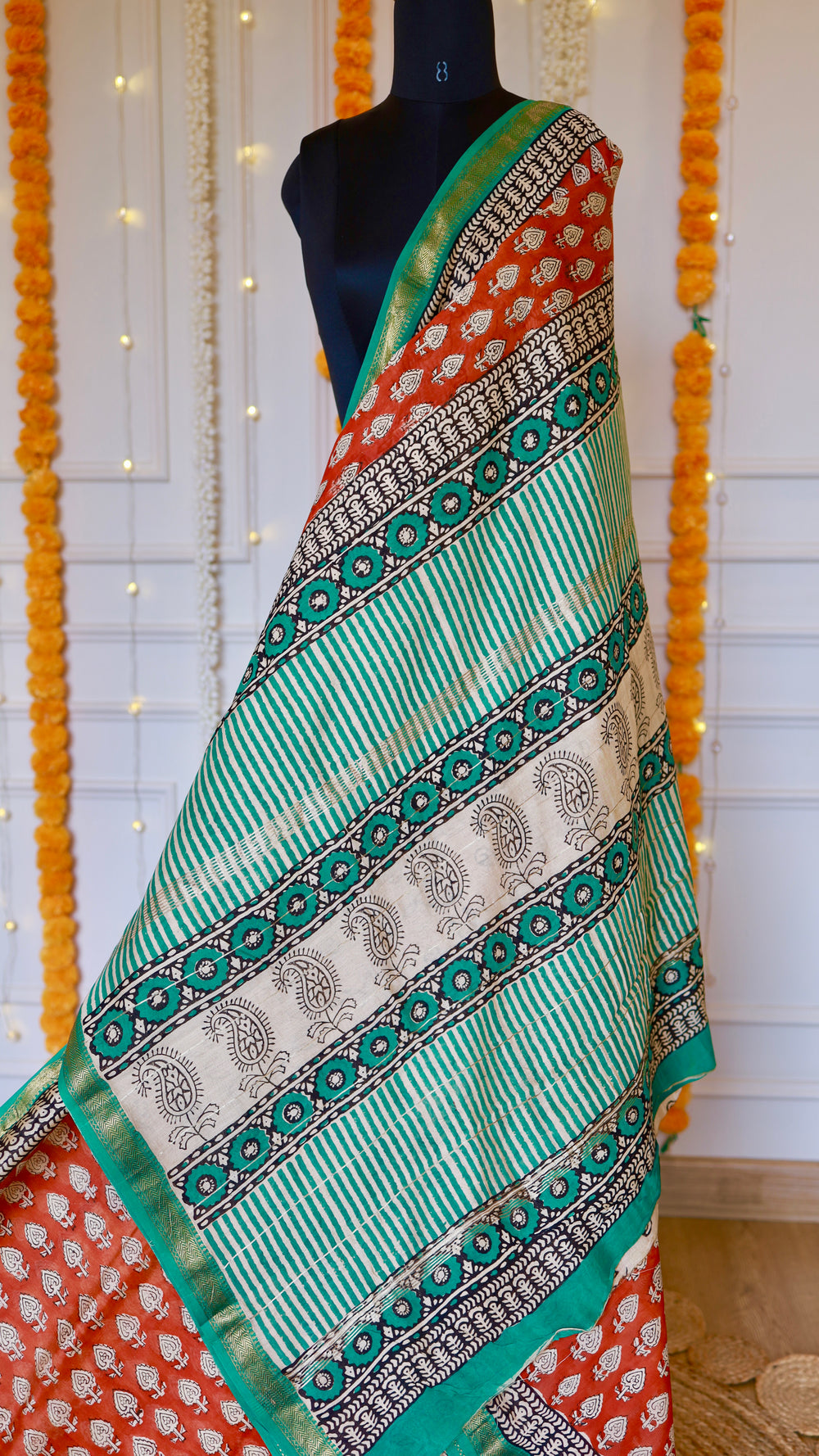 Draped pallu view of Rust Red Maheshwari Silk Saree showing green stripe patterns and paisley block prints.