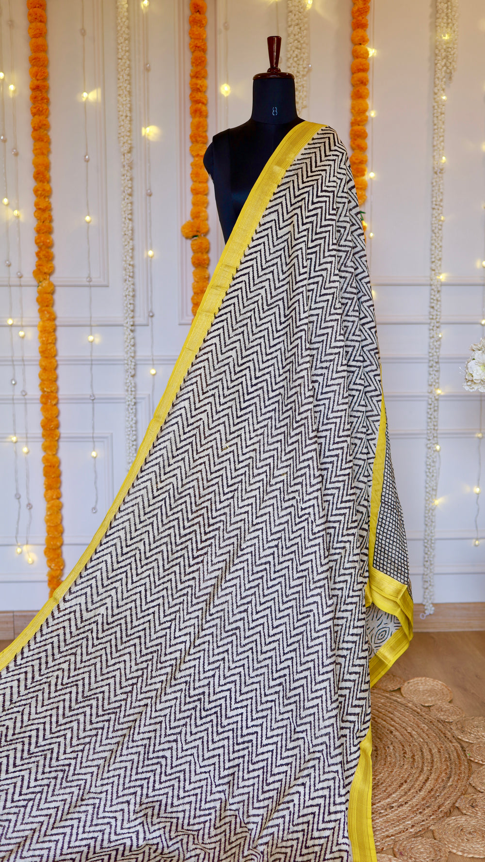 Full pleat display of the black and white zig-zag print Maheshwari Silk Saree highlighted by its yellow selvedge.