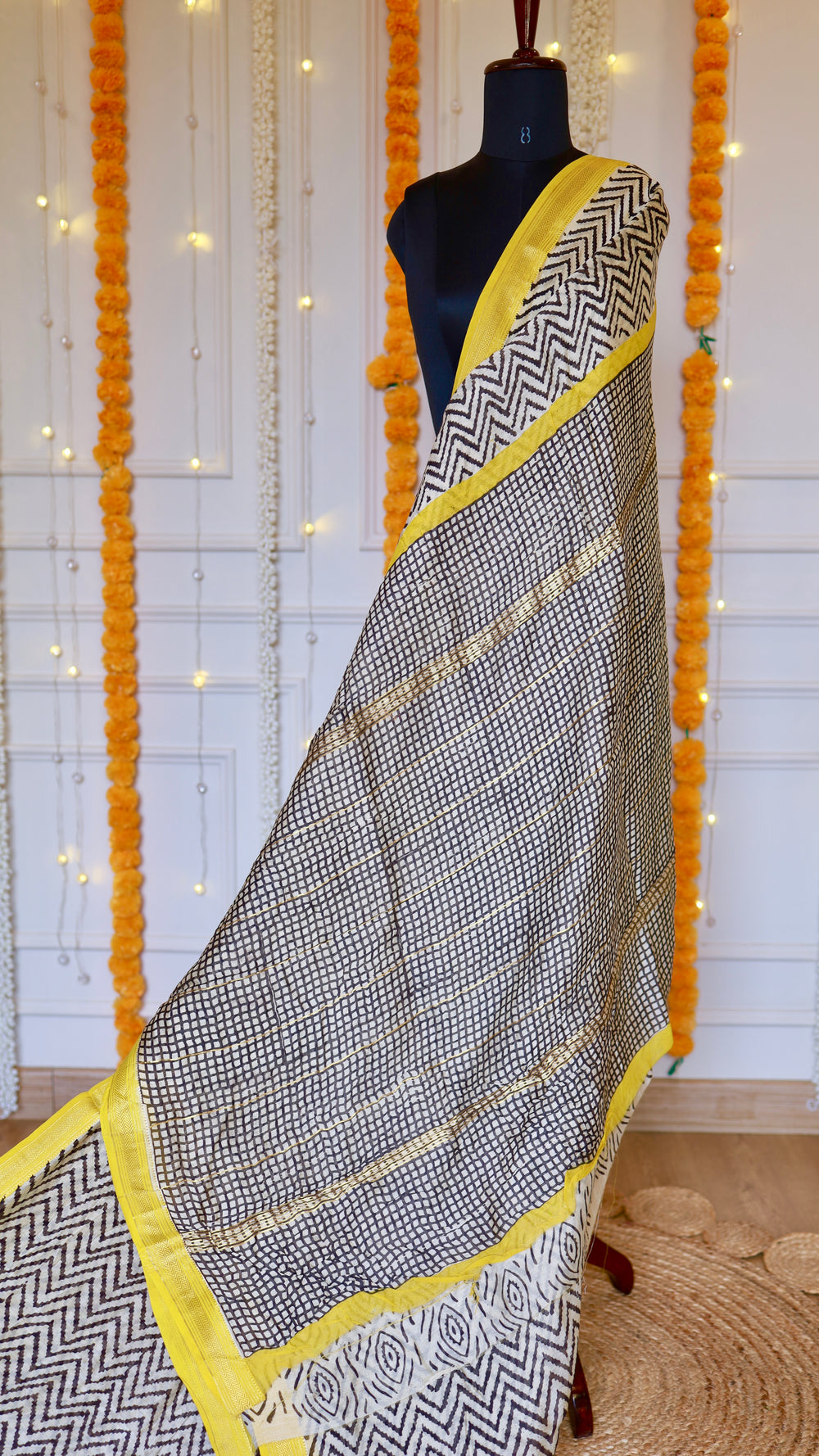 Pallu detail of the off-white Maheshwari Silk Saree showing black grid checks and thin gold zari woven stripes.