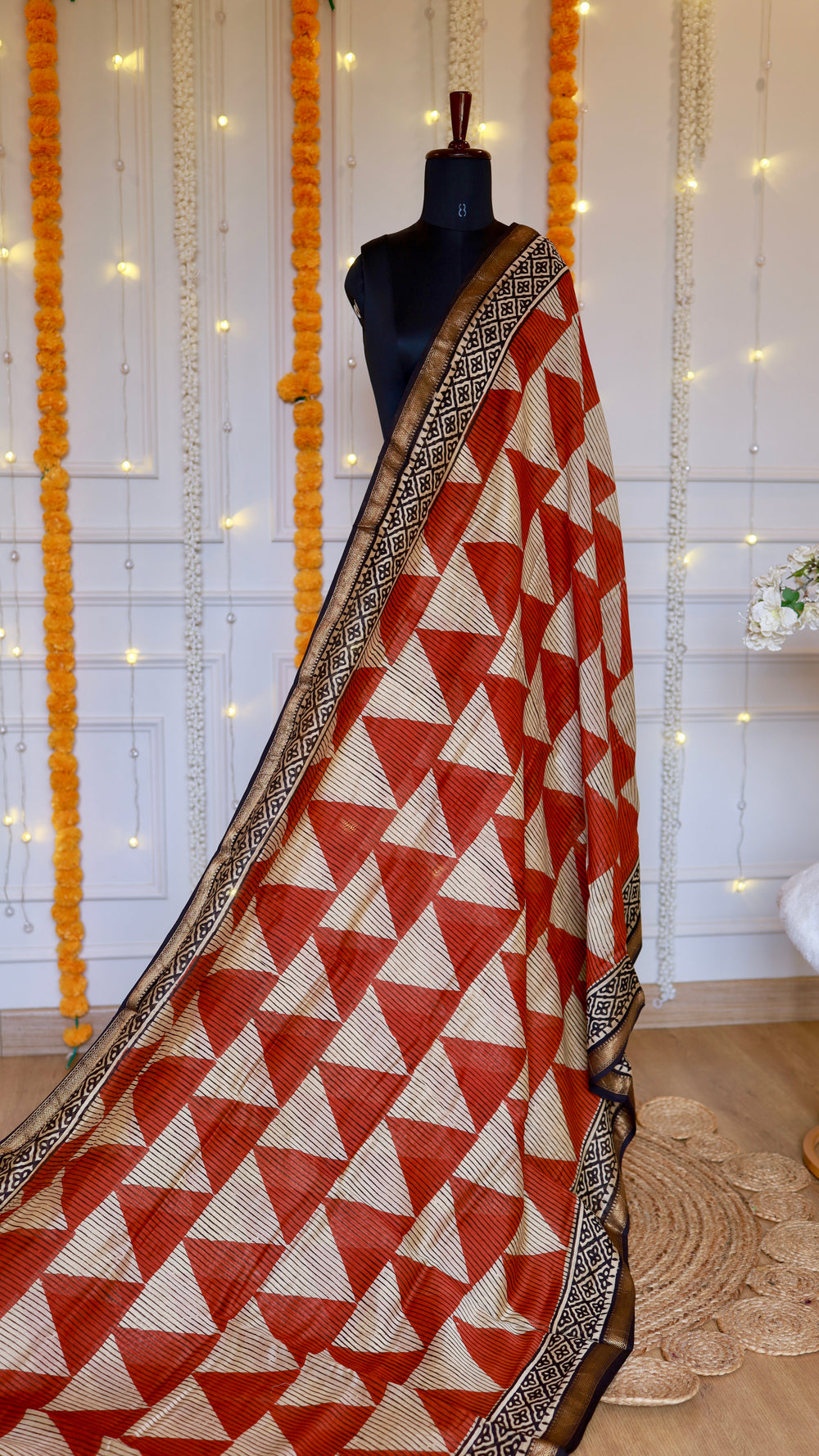 Rust orange and beige geometric triangle printed Maheshwari silk saree draped on mannequin