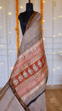 Detailed view of rust red pallu featuring hand block printed paisley motifs on beige Maheshwari silk drape