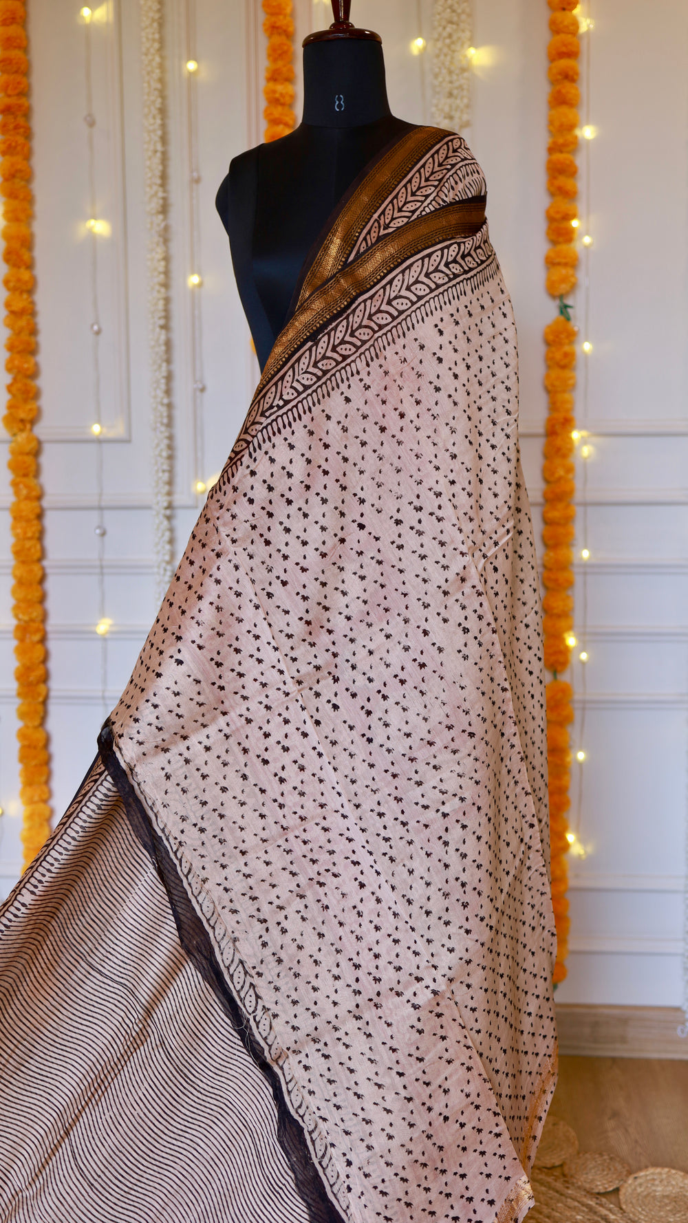Rear pleat view of light beige Maheshwari silk saree displaying subtle floral hand block motifs