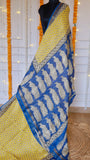 Handblock printed Maheshwari silk saree showing mustard yellow body with royal blue paisley pallu and zari border draped on mannequin.